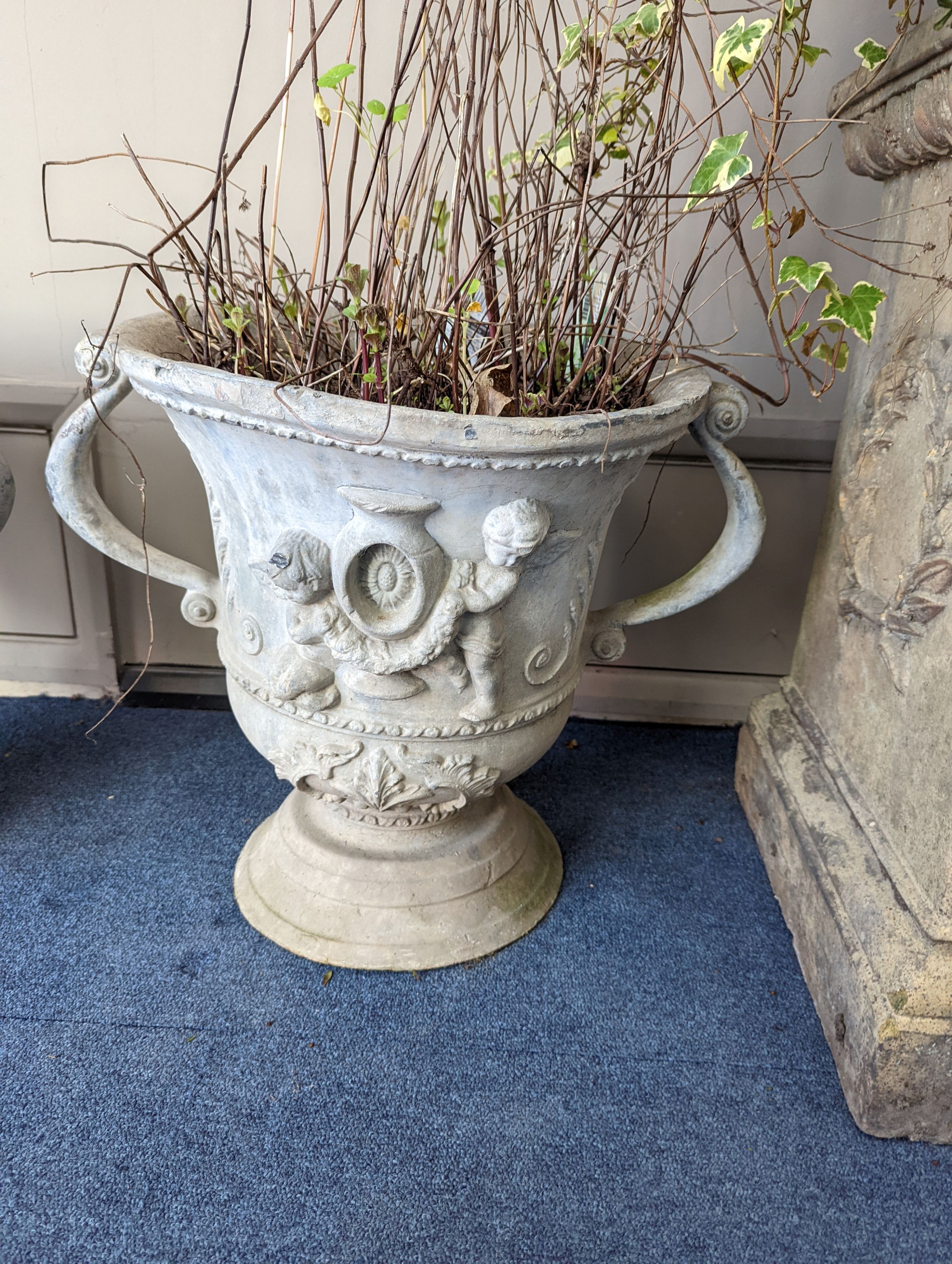 A set of three Victorian lead two handled garden planters, moulded with cherubs, diameter 38cm, height 43cm